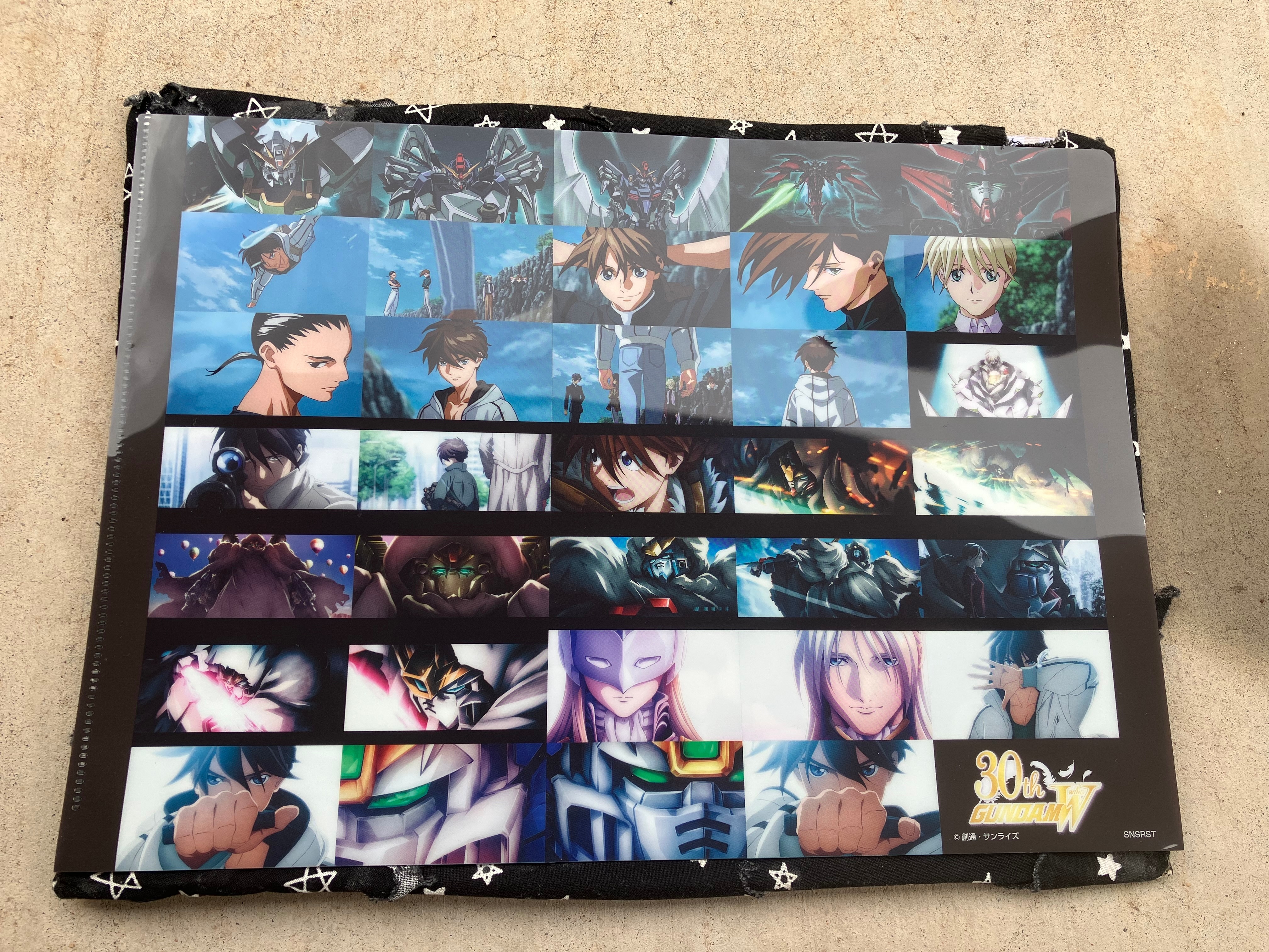 Back of clear file with various scenes of Gundam wing 30th anniversary animation.